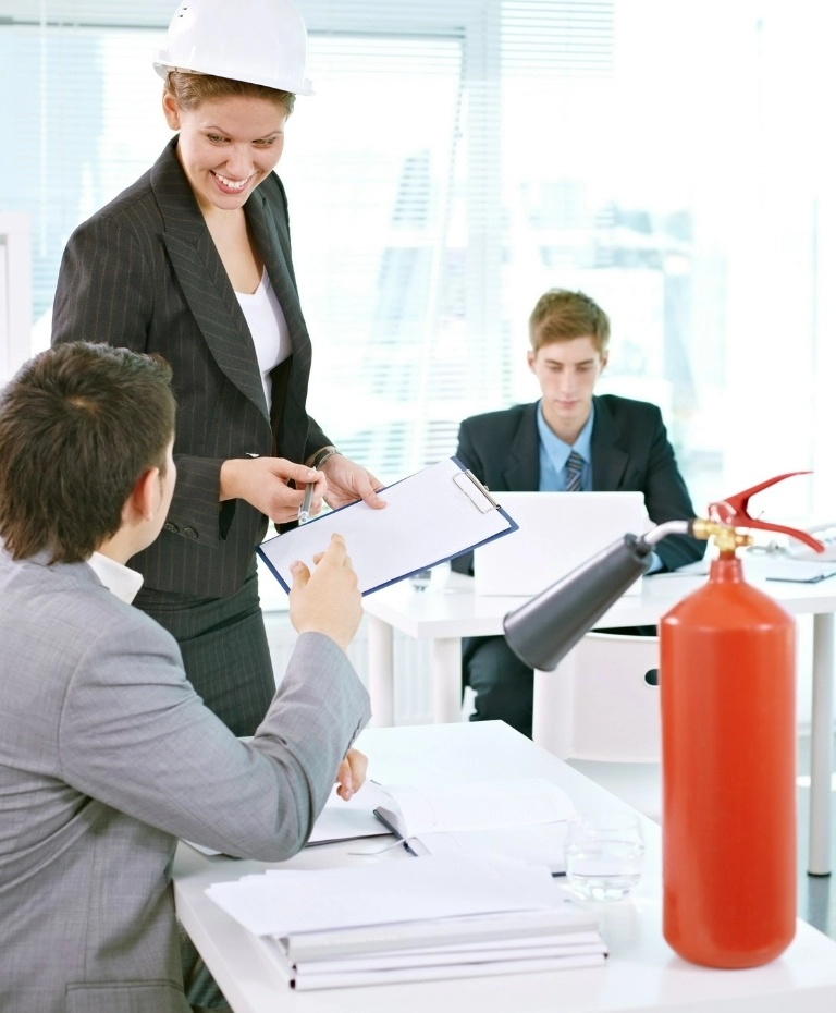 Pracownicy w&nbsp;biurze i&nbsp;gaśnica na&nbsp;laptopie